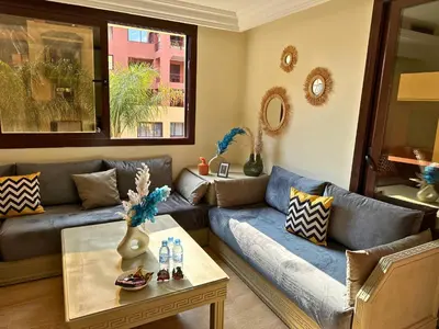 a living room with a couch and a table at Appartement de Luxe avec Piscine et Jacuzzi Marrakech in Marrakech