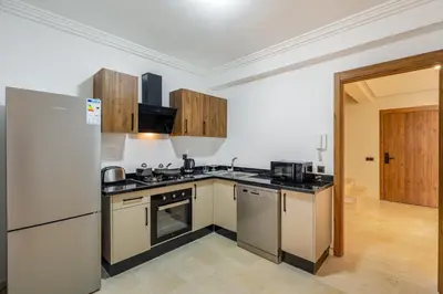 a kitchen with a refrigerator and a stove top oven at L'Elara - Semlalia - Duplex - Piscine in Marrakech