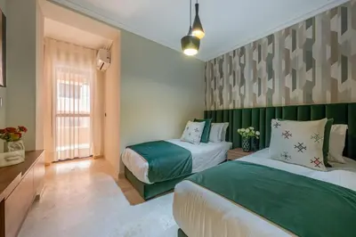 two beds in a room with green and white at L'Elara - Semlalia - Duplex - Piscine in Marrakech