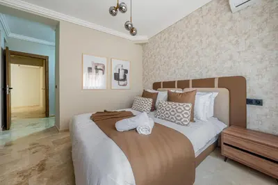 a bedroom with a large bed with pillows at L'Elara - Semlalia - Duplex - Piscine in Marrakech