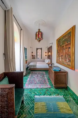 a bedroom with a bed and a couch and a table at Riad Dar Amani in Marrakech