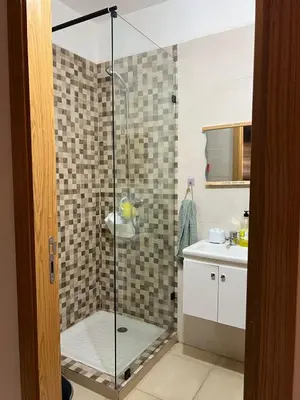 a shower with a glass door in a bathroom at New, quiet and comfortable in Marrakech