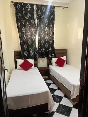 two beds in a small room with a curtain at Dar wafa in Marrakech