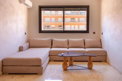 a living room with a couch and a window at Heart of Marrakech - Hivernage 2 bedroom apartment in Marrakech