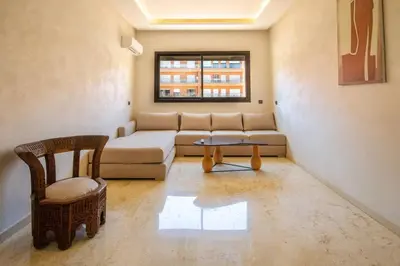 a living room with a couch and a chair at Heart of Marrakech - Hivernage 2 bedroom apartment in Marrakech