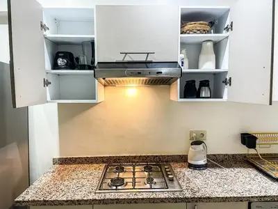 a kitchen with a stove and white cabinets at Elegant 3-Bedroom Duplex Downtown Private Terrace in Marrakech