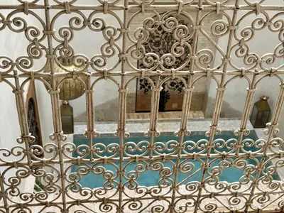 a view through a metal fence with a mirror at Riad Dar Familya in Marrakech