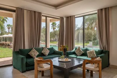a living room with a green couch and a table at 2 Superbe villas avec chacune piscine privée & jardin 5 ou 6 chambres in Marrakech
