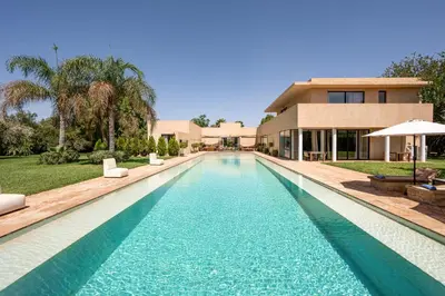 a swimming pool in front of a house at 2 Superbe villas avec chacune piscine privée & jardin 5 ou 6 chambres in Marrakech
