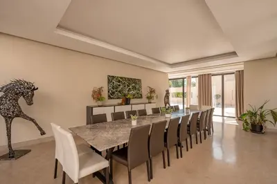 a dining room with a table and chairs at 2 Superbe villas avec chacune piscine privée & jardin 5 ou 6 chambres in Marrakech