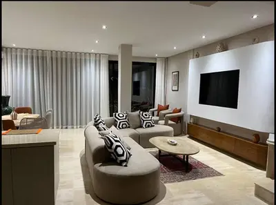 a living room with a couch and a tv at Villa Dar Moumoune à Marrakech, piscine chauffée en option in Sraghna