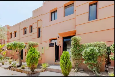 a building with bushes and trees in front of it at Villa Dar Moumoune à Marrakech, piscine chauffée en option in Sraghna