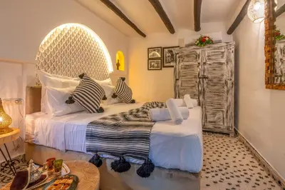 a bedroom with a large bed with striped pillows at Dar Bonita in Marrakech