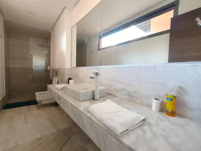 a bathroom with a sink and a mirror at Duplex Premium 3 Suites, Style Villa, Terrasse & Accès direct piscine, Oliver Palm Resort Marrakech in Marrakech