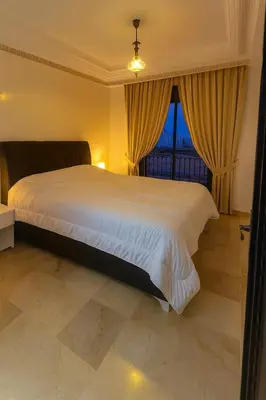 a bedroom with a large white bed and a window at Studio cosy Centre ville à 4 min et stade à 6 min in Marrakech