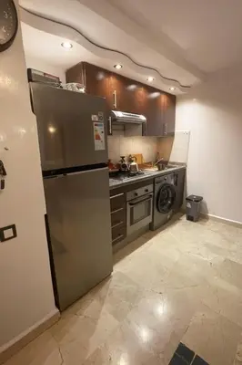 a kitchen with a stainless steel refrigerator and a dishwasher at Studio cosy Centre ville à 4 min et stade à 6 min in Marrakech