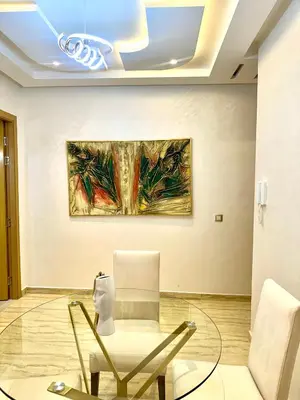 a room with a chair and a painting on the wall at Séjournez dans un appart moderne, calme et tout équipé à Marrakech in Marrakech