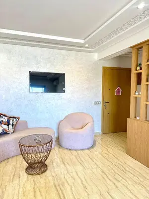 a living room with a pink couch and a ottoman at Séjournez dans un appart moderne, calme et tout équipé à Marrakech in Marrakech