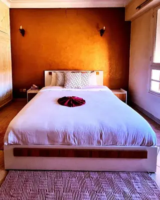 a bedroom with a large bed with a red bow on it at Hide & seek in Marrakech