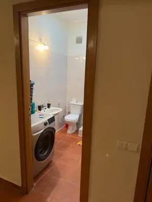 a bathroom with a washing machine and a toilet at The cozy Den in Marrakech