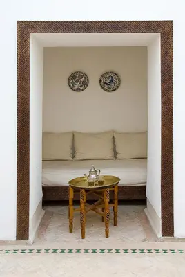 a room with a bed with a table and plates on the wall at Riad Porte Royale in Marrakech