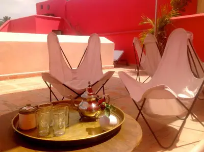 a table with chairs and a tray with glasses on it at Riad Porte Royale in Marrakech