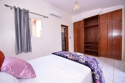 a bedroom with a bed and a wooden cabinet at Le riad de Daba in Marrakech
