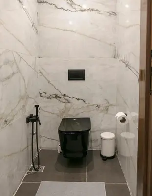 a bathroom with a black tub and a toilet at Luxury Designer Apartment Central Marrakech in Marrakech