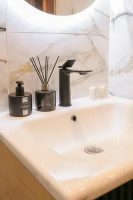 a bathroom sink with two complimentary items on it at Luxury Designer Apartment Central Marrakech in Marrakech