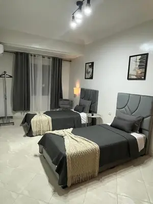 a bedroom with two beds and a chair at GZ Loft in Marrakech