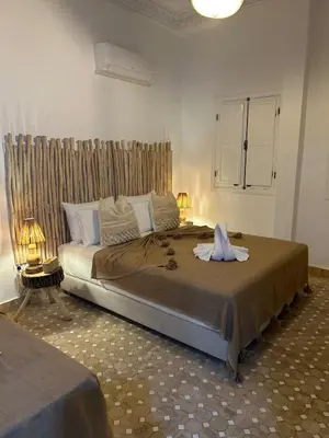 a bedroom with a large bed in a room at Dar Farah Riad luxe privé, 3ch, piscine chauffée, ptit déj in Marrakech