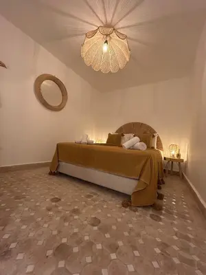 a bedroom with a bed and a chandelier at Dar Farah Riad luxe privé, 3ch, piscine chauffée, ptit déj in Marrakech