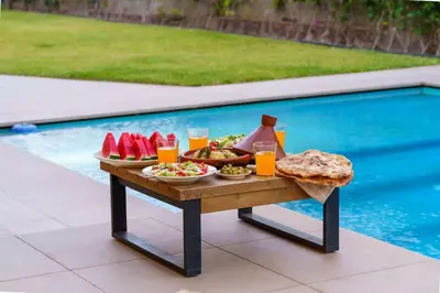 a tray of food on a table next to a pool at Villa R, luxury, gym, private pool in Marrakech