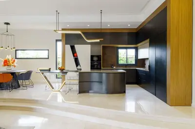a kitchen with black cabinets and a dining room at Villa R, luxury, gym, private pool in Marrakech