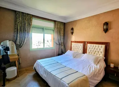 a bedroom with a large bed and a window at Bloom Hivernage Deluxe - 2 Chambres - Le Soleil en Mars - Petit déjeuner et Services de chambres inclus - A 10mn des sites - Balcon végétal in Marrakech