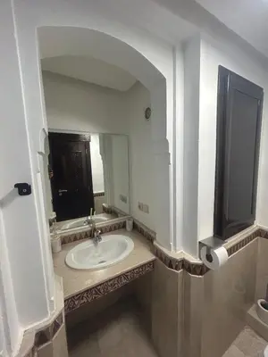 a bathroom with a sink and a large mirror at Appartement neuf hivernage in Marrakech