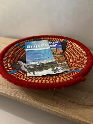 a basket with magazines on top of a table at Les jardins de Carlota in Marrakech