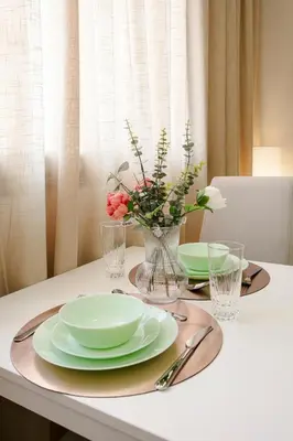 a table with two plates and a vase with flowers at Le Nomadic Chic Piscine Privée in Marrakech