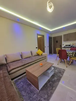 a living room with a couch and a table at Élégante Appartement au centre de Marrakech , Piscine - Parking gratuit in Marrakech