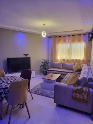 a living room with a couch and a tv at Élégante Appartement au centre de Marrakech , Piscine - Parking gratuit in Marrakech