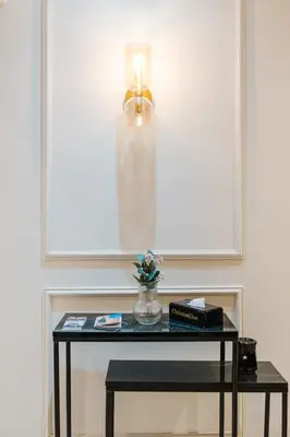 a table with a vase of flowers and a lamp at Un Appartement d'exception in Marrakech