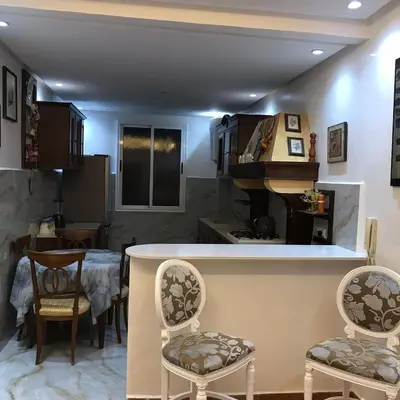 a kitchen with a bar with chairs and a piano at Cozy Stay Central Marrakech in Marrakech