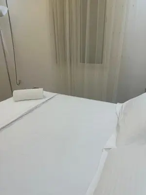 a white bed in a room with a window at Cozy Stay Central Marrakech in Marrakech