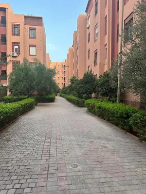 a cobblestone street in a city with tall buildings at Cozy Stay Central Marrakech in Marrakech