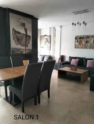a living room with a table and a couch at Pavillon Luxe - Jardin de l'Atlas - Golf & Waky in Sraghna