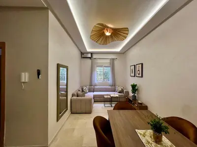 a living room with a table and a couch at Appartement cosy et moderne familial in Marrakech