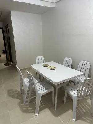a white dining room table and chairs with a white table and white chairs at New and nice apartment in Marrakech