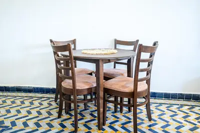 a wooden table with four chairs and a table at Palmeraie Tradition and Modernity in Marrakech