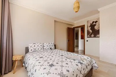 a bedroom with a bed and a table in it at Rent Appartment In Marrakesh - Morocco - Semlalia in Marrakech