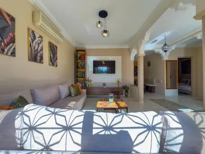 a living room with a couch and a table at Appartement lumineux avec Jardin à la palmeraie in Marrakech